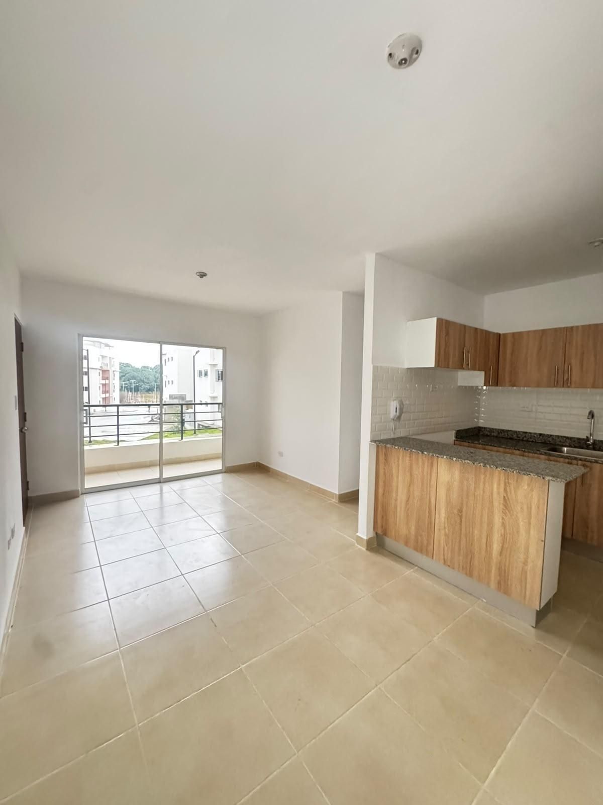 Sala-comedor con cocina integrada y salida al balcón.